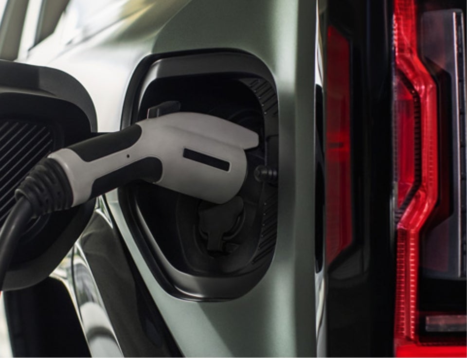 Close up of charging port with charger plugged in on a GMC Hummer EV SUV - Durand GMC in Leominster MA
